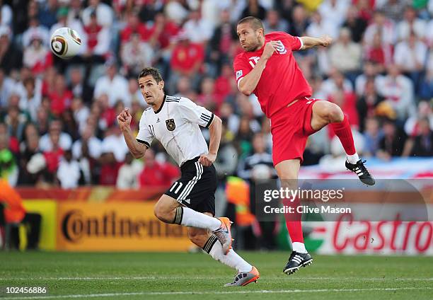 Matthew Upson of England heads the ball challenged by Miroslav Klose of Germany during the 2010 FIFA World Cup South Africa Round of Sixteen match...