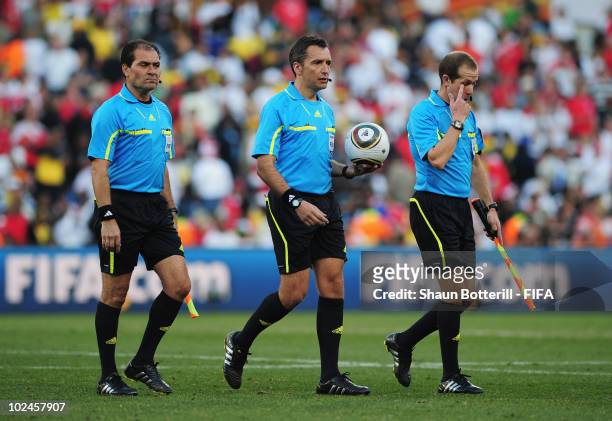 The referee Jorge Larrionda leaves the pitch at halftime with linesmen Pablo Fandino and Mauricio Espinosa during the 2010 FIFA World Cup South...
