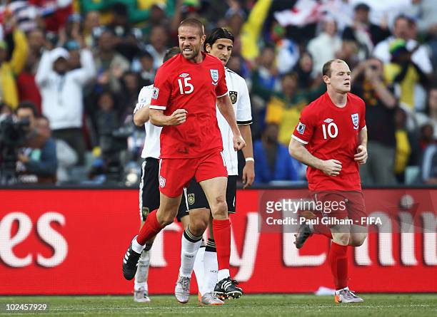 Matthew Upson of England celebrates scoring with teammate Wayne Rooney during the 2010 FIFA World Cup South Africa Round of Sixteen match between...