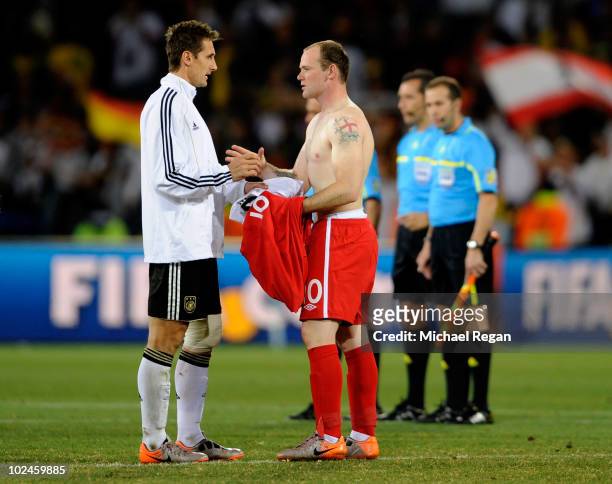 Dejected Wayne Rooney of England swaps shirts with Miroslav Klose of Germany after the 2010 FIFA World Cup South Africa Round of Sixteen match...