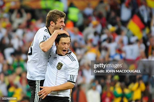 Germany's midfielder Thomas Mueller celebrates with Germany's midfielder Mesut Ozil after scoring the team's fourth goal during the 2010 World Cup...