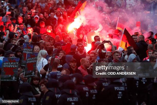 Right wing demonstrators light flares on August 27, 2018 in Chemnitz, eastern Germany, following the death of a 35-year-old German national who died...