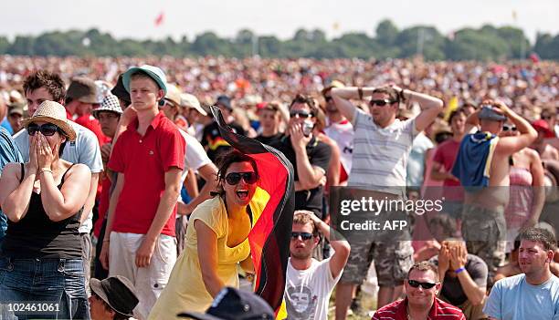 German football fan reacts to one of the goals against England while surrounded by English football fans on the final day of the Glastonbury festival...