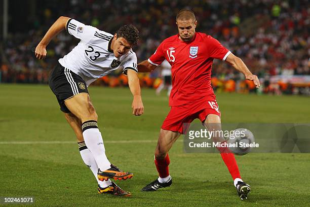 Matthew Upson of England defends a cross by Mario Gomez of Germany during the 2010 FIFA World Cup South Africa Round of Sixteen match between Germany...