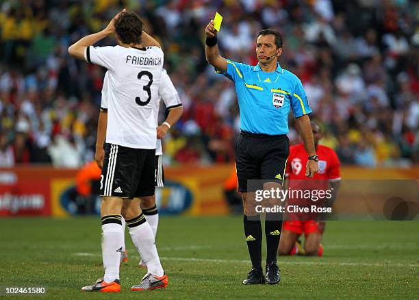 Arne Friedrich of Germany receives a yellow card from referee Jorge Larrionda during the 2010 FIFA World Cup South Africa Round of Sixteen match...