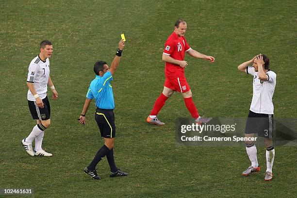 Arne Friedrich of Germany receives a yellow card from referee Jorge Larrionda during the 2010 FIFA World Cup South Africa Round of Sixteen match...