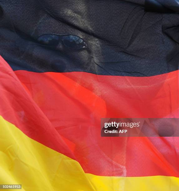 Fan of the German national football team waves a flag during the public viewing event of the World Cup match between England and Germany in the...