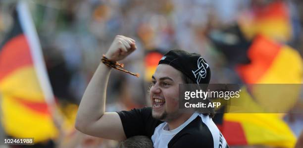 Fan of the German national football team cheers the public viewing event of the World Cup match between England and Germany in the southern German...