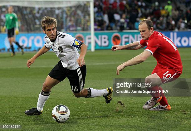 Philipp Lahm of Germany is chased by Wayne Rooney of England during the 2010 FIFA World Cup South Africa Round of Sixteen match between Germany and...