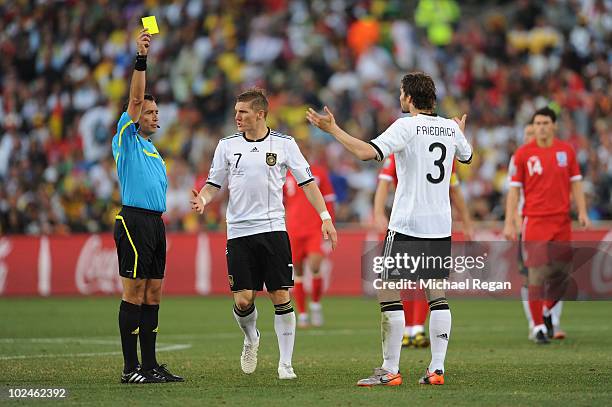 Arne Friedrich of Germany receives a yellow card from referee Jorge Larrionda during the 2010 FIFA World Cup South Africa Round of Sixteen match...