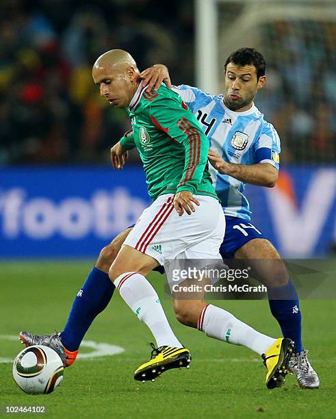 Javier Mascherano of Argentina tackles Adolfo Bautista of Mexico during the 2010 FIFA World Cup South Africa Round of Sixteen match between Argentina...