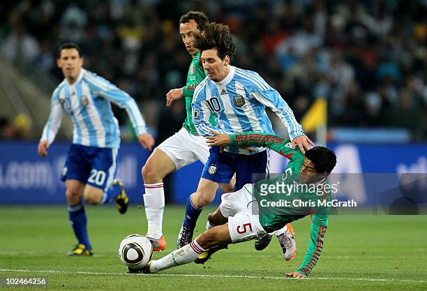 Lionel Messi of Argentina is tackled by Ricardo Osorio of Mexico during the 2010 FIFA World Cup South Africa Round of Sixteen match between Argentina...