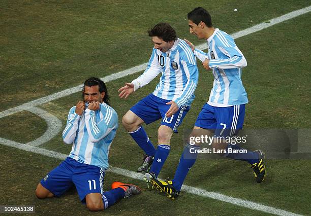 Carlos Tevez of Argentina celebrates scoring the opening goal with Lionel Messi and Angel Di Maria of Argentina during the 2010 FIFA World Cup South...