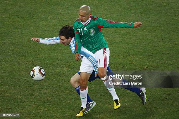 Lionel Messi of Argentina is tackled by Adolfo Bautista of Mexico during the 2010 FIFA World Cup South Africa Round of Sixteen match between...