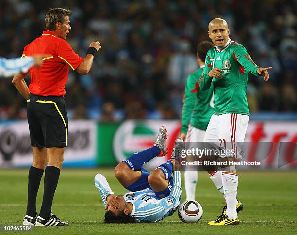 Referee Roberto Rosetti talks to Adolfo Bautista of Mexico following a challenge with Carlos Tevez of Argentina during the 2010 FIFA World Cup South...