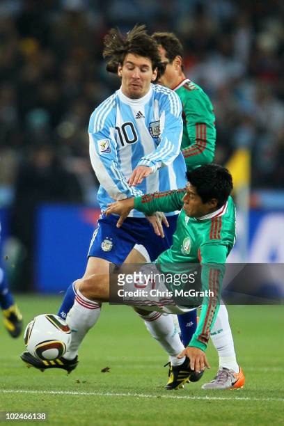 Lionel Messi of Argentina tackles Ricardo Osorio of Mexico during the 2010 FIFA World Cup South Africa Round of Sixteen match between Argentina and...