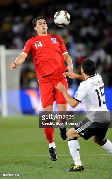 Gareth Barry heads the ball with Piotr Trochowski of Germany during the 2010 FIFA World Cup South Africa Round of Sixteen match between Germany and...