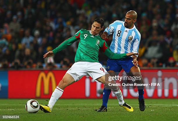 Guillermo Franco of Mexico is challenged by Juan Veron of Argentina during the 2010 FIFA World Cup South Africa Round of Sixteen match between...