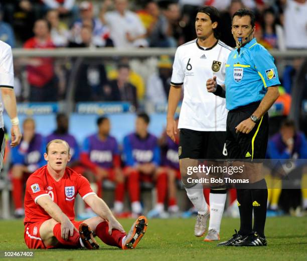 Referee Jorge Larrionda stands next to Wayne Rooney of England during the 2010 FIFA World Cup South Africa Round of Sixteen match between Germany and...