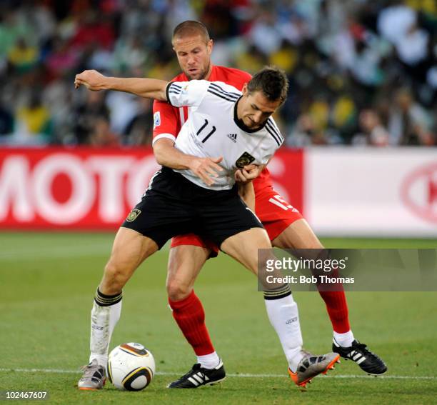 Miroslav Klose of Germany clashes with Matthew Upson of England during the 2010 FIFA World Cup South Africa Round of Sixteen match between Germany...