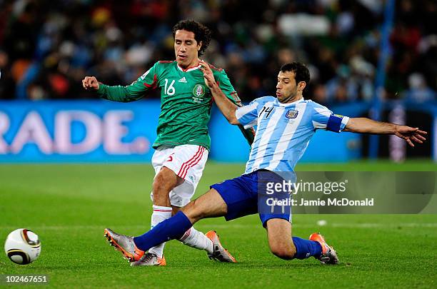 Javier Mascherano of Argentina tackles Efrain Juarez of Mexico during the 2010 FIFA World Cup South Africa Round of Sixteen match between Argentina...