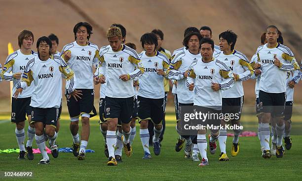 The Japanese players run a lap of the pitch at a Japan training session during the FIFA 2010 World Cup at the Super Stadium on June 27, 2010 in...