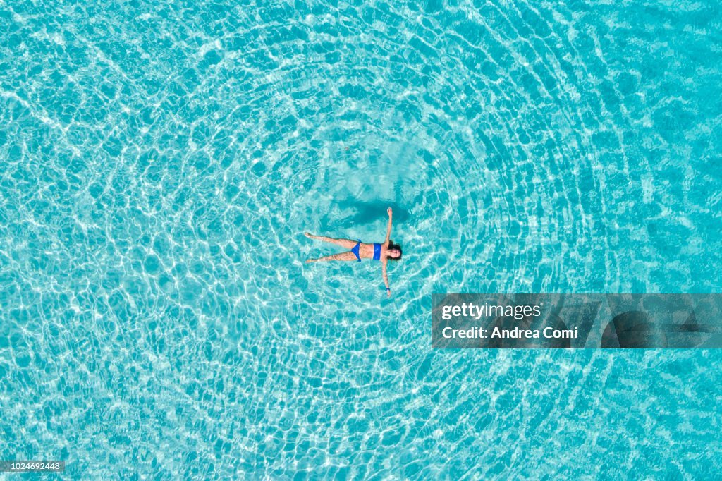 Relaxed woman stays afloat at sea