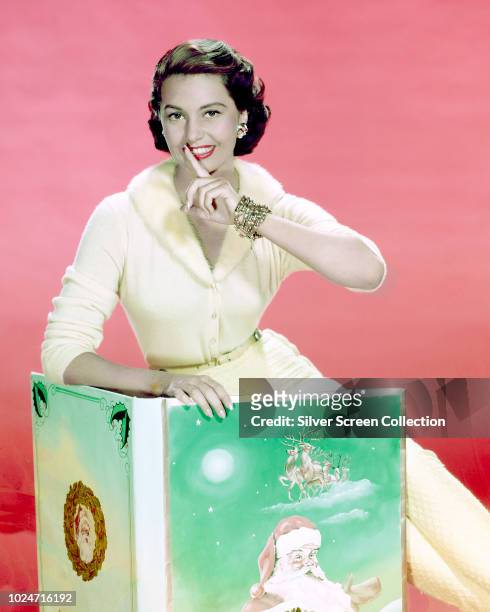 American actress and dancer Cyd Charisse reads a Christmas book, circa 1950.