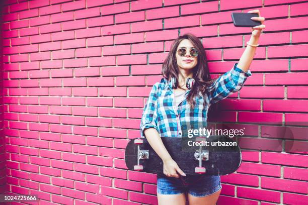 girl by pink brick wall with skateboard - brick phone stock pictures, royalty-free photos & images