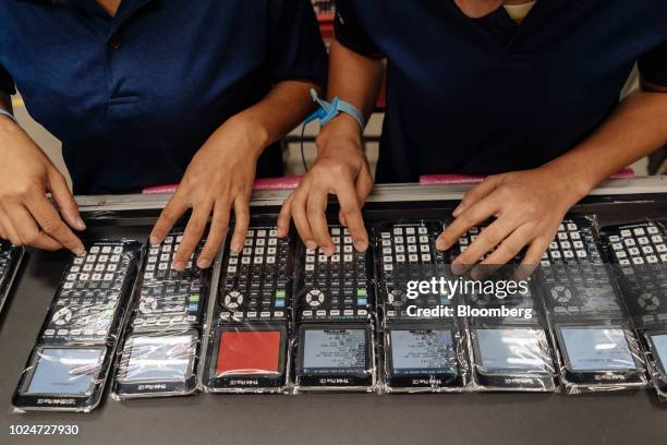 Employees program Texas Instruments Inc. TI-84 Plus CE graphing calculators at a facility of Cal-Comp Technology Philippines Inc., a unit of New...