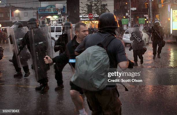 Police officer threatens to punch a photographer taking pictures of a journalist being arrested at the G20 summits June 27, 2010 in Toronto, Canada....