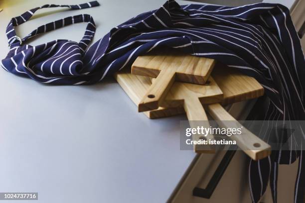 kitchen apron and wooden cutting boards on kitchen table - tablier photos et images de collection