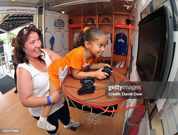 Fan and her mother play the the new NBA Live video game during the NBA Nation tour on June 27, 2010 in Philadelphia, Pennsylvania. NOTE TO USER: User...