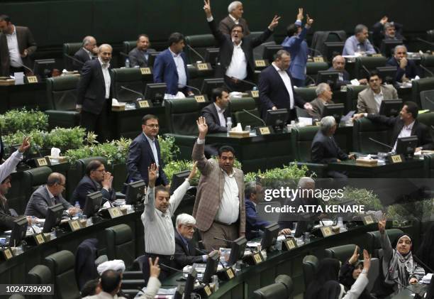 Members of the Iranian Parliament gesture as President Hassan Rouhani speaks in the capital Tehran, on August 28, 2018. It was the first time Rouhani...