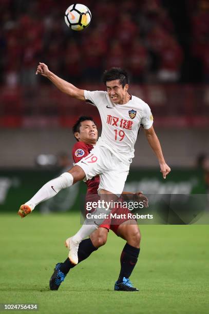 Wang Xiaolong of Tianjin Quanjian heads the ball in front of Yasushi Endo of Kashima Antlers during the AFC Champions League Round of 16 first leg...