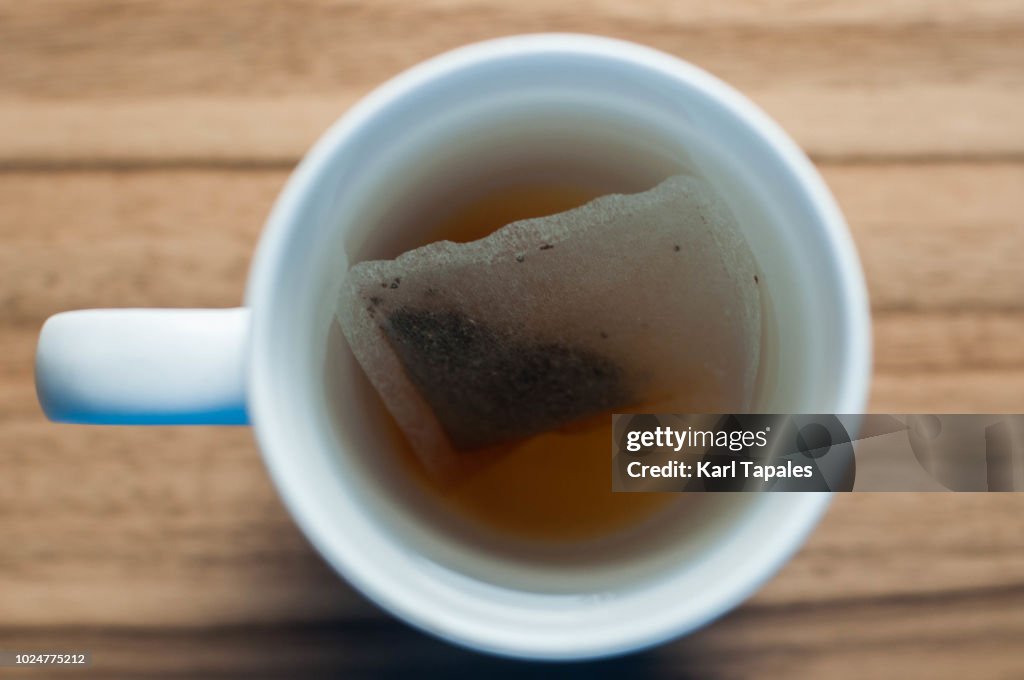 A fresh teabag in white mug with hot water