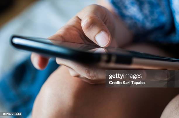 a woman is using a mobile phone - message sms ストックフォトと画像