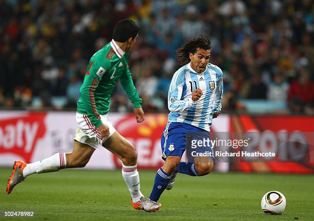 Carlos Tevez of Argentina goes past Francisco Rodriguez of Mexico during the 2010 FIFA World Cup South Africa Round of Sixteen match between...