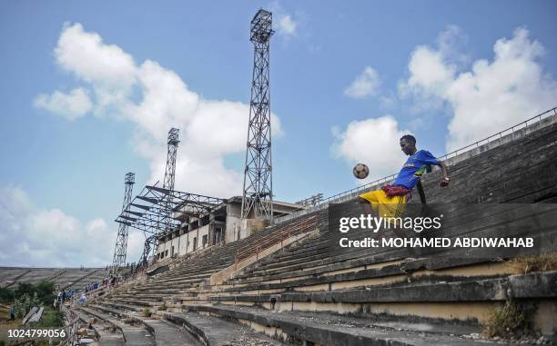 Somali boy handles a ball at the Mogadishu stadium after African Union Mission to Somalia left the stadium in Mogadishu, Somalia, on August 28, 2018....