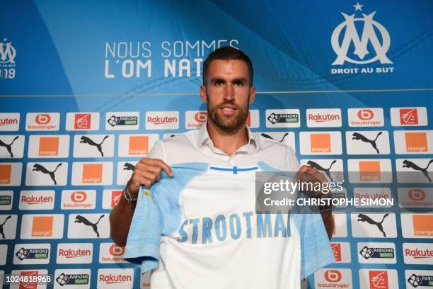 Olympique de Marseille 's Dutch midfielder Kevin Strootman poses with his new football jersey, during a press conference on August 28 in Marseille. -...
