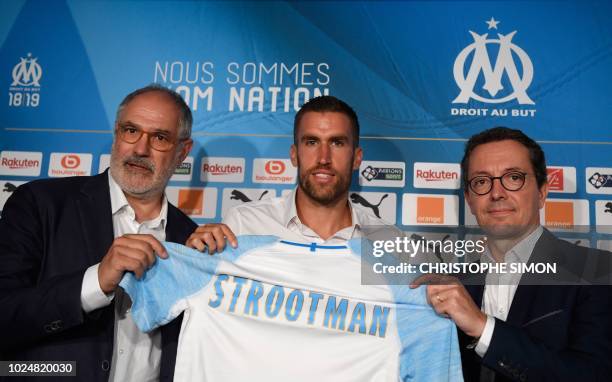 Olympique de Marseille 's Dutch midfielder Kevin Strootman poses with his new football jersey next to with Olympique de Marseille's sportive manager...