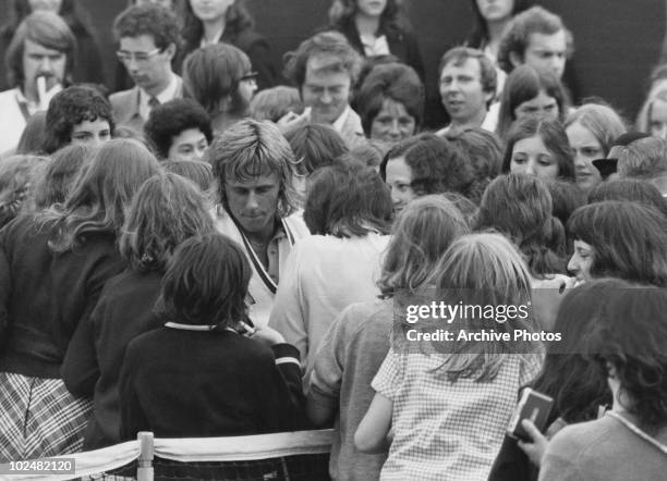 Swedish tennis player Bjorn Borg surrounded by young female fans at Wimbledon, 28th June 1973.
