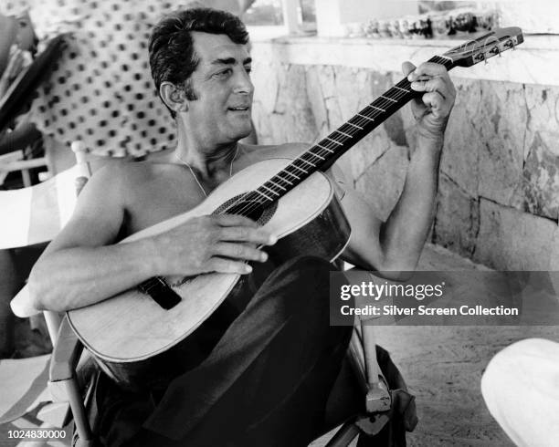 American actor and singer Dean Martin playing the guitar, circa 1960.