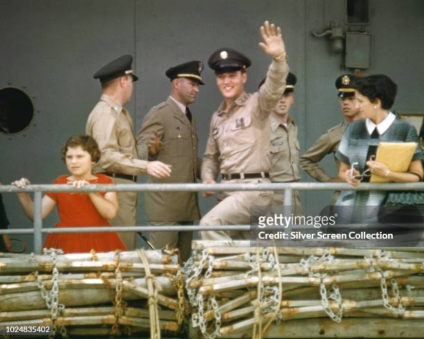 American singer and actor Elvis Presley waves to his fans from the 'USS Randall' at the New York Port of Embarkation's Brooklyn Army Terminal , New...