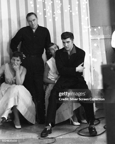 American singer Elvis Presley sitting with disc jockey Dewey Phillips during his appearance on Wink Martindale's television show 'Teenage Dance...