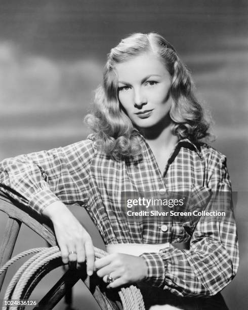 American actress Veronica Lake wearing a plaid shirt and holding a rope, circa 1945.