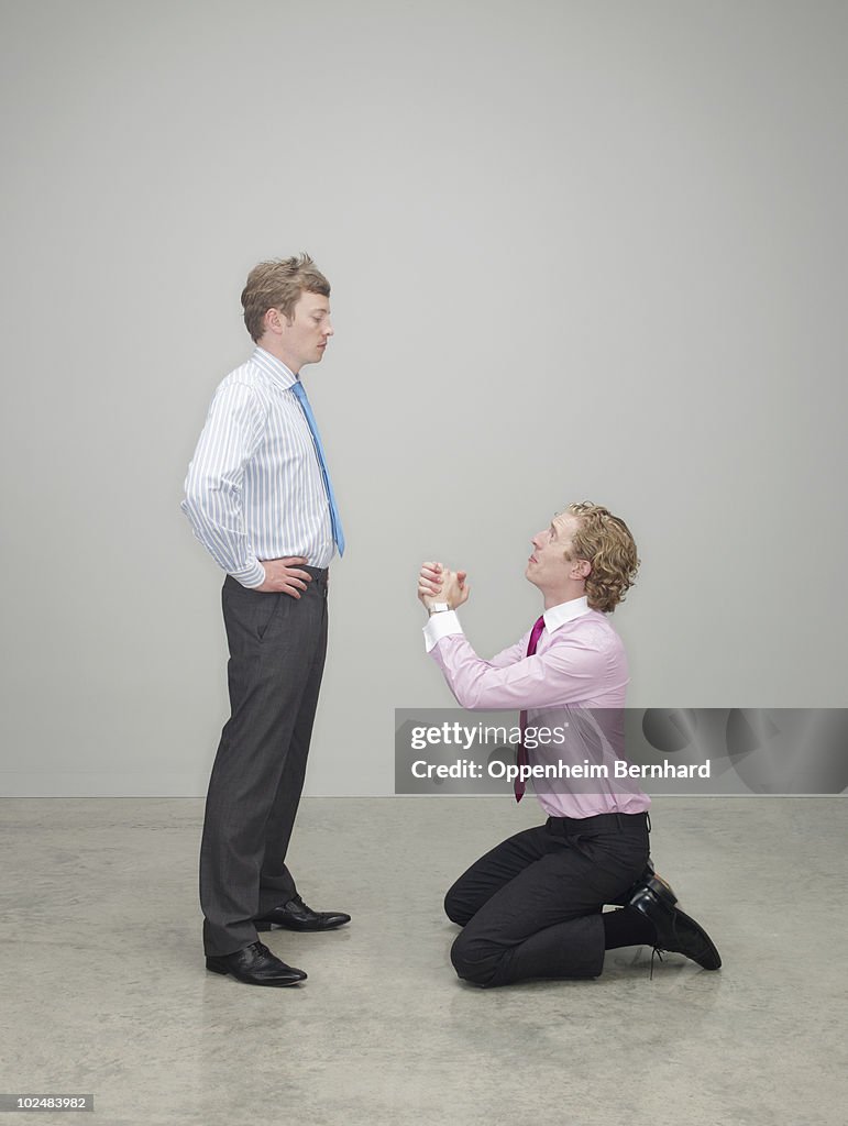 Businessman begging on his knees