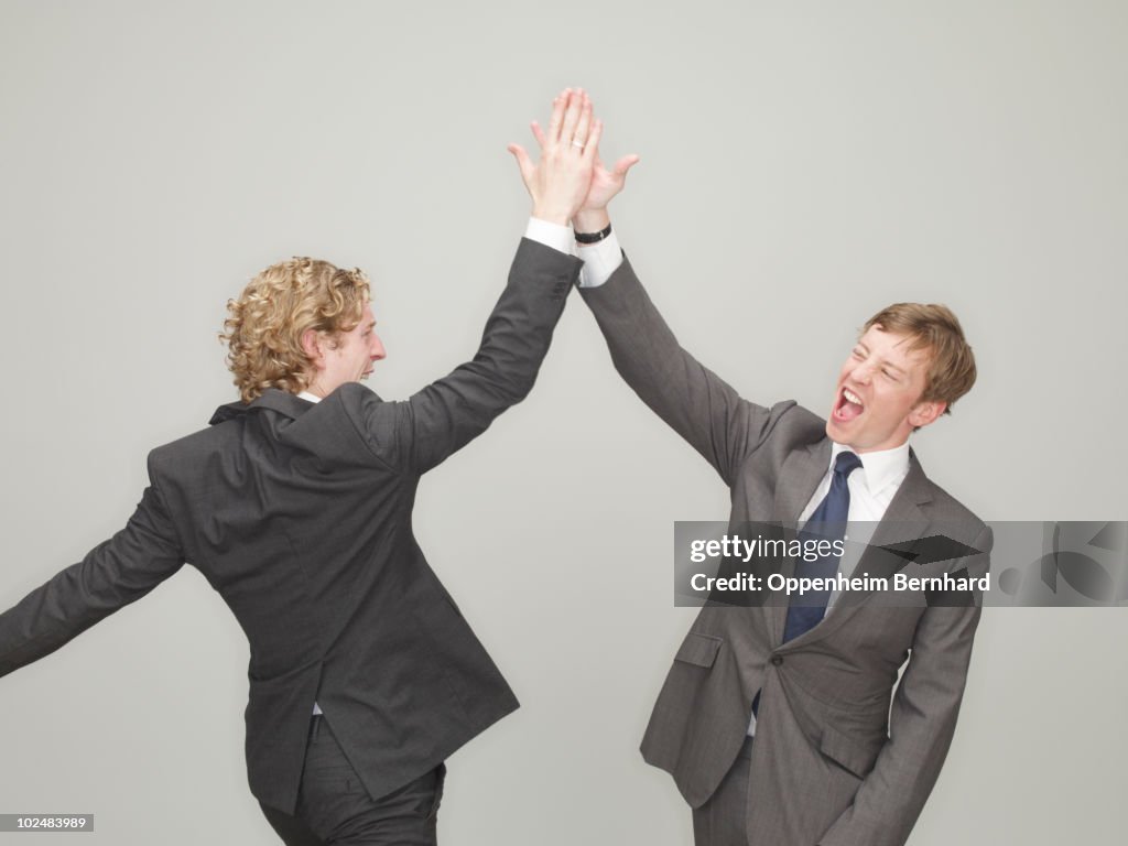 Businessmen high fiving