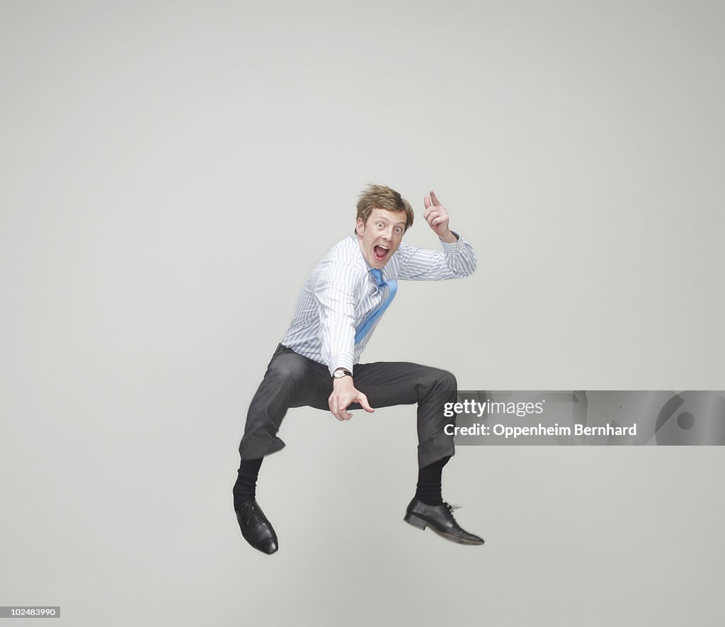 Businessman jumping in the air smiling