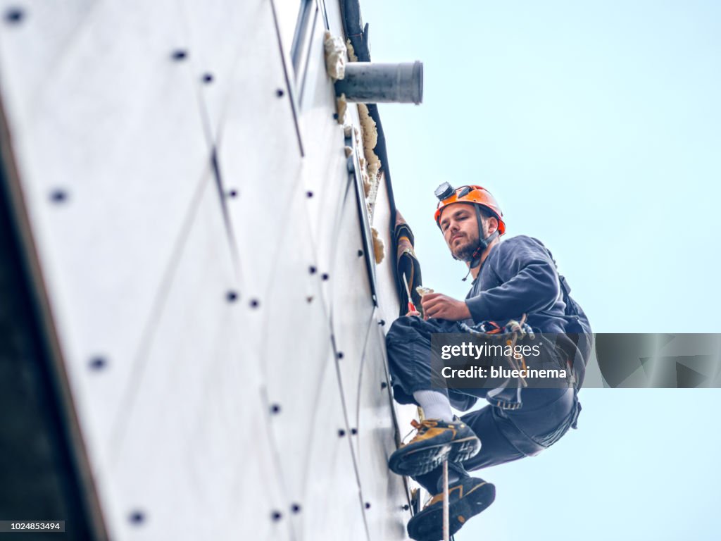 Abseiling building maintenance workers at work